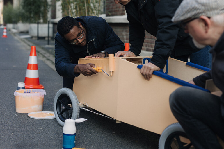 Team bemalt Seifenkiste mit Farbe beim Seifenkistenrennen von Stadthelden
